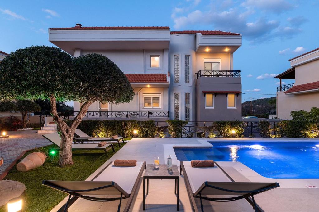 a villa with a swimming pool at night at Emmelia Villa in Ialyssos