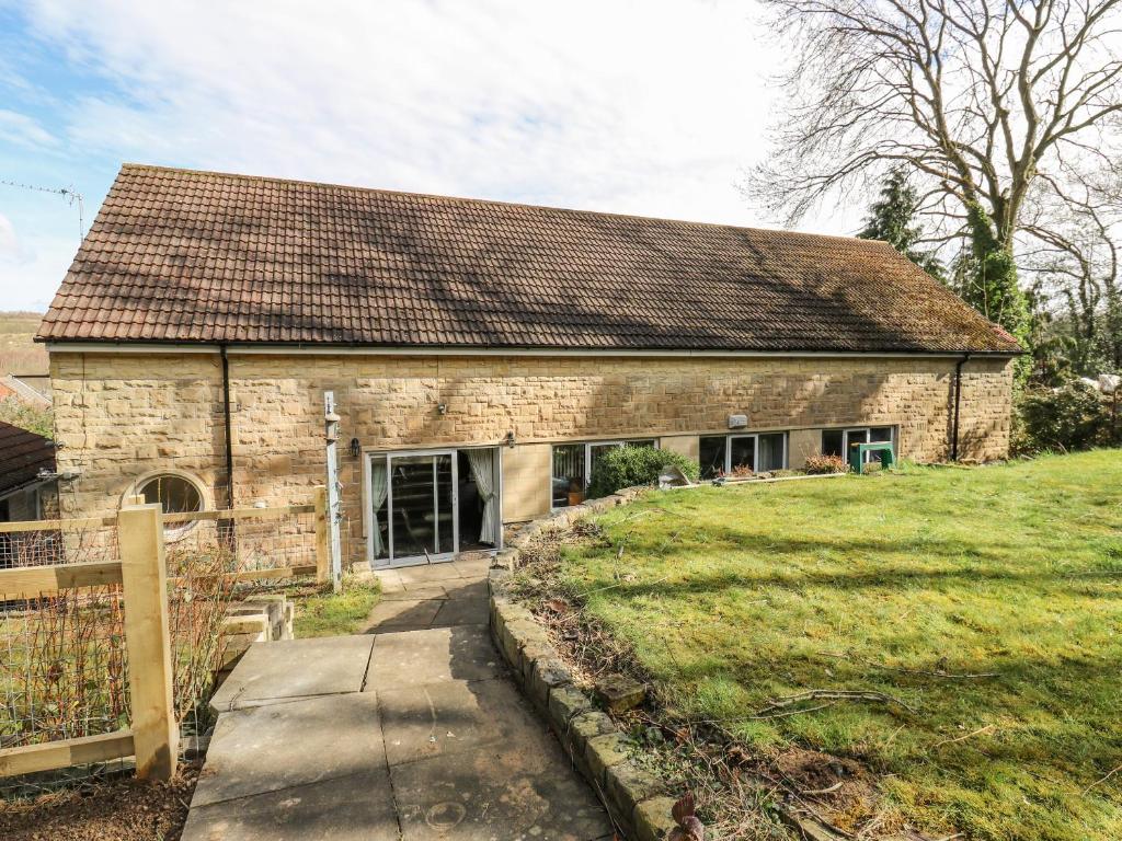 a stone house with a grassy yard in front of it at Call A Mia in Doncaster