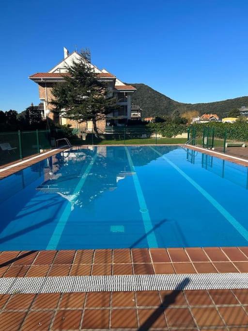 uma grande piscina azul com um edifício ao fundo em Playa de Berria - Precioso Apartamento con piscina, Garaje incluido e INTERNET em Santoña