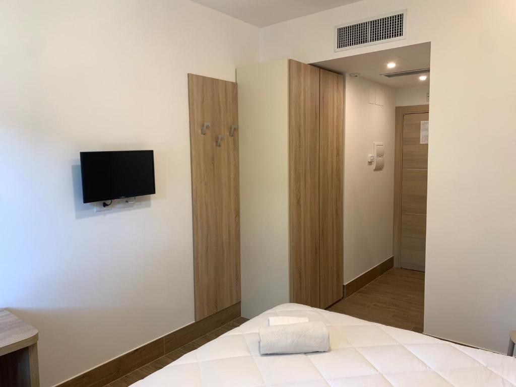 a bedroom with a bed and a tv on a wall at San Giuseppe Casa per Ferie in Quercianella