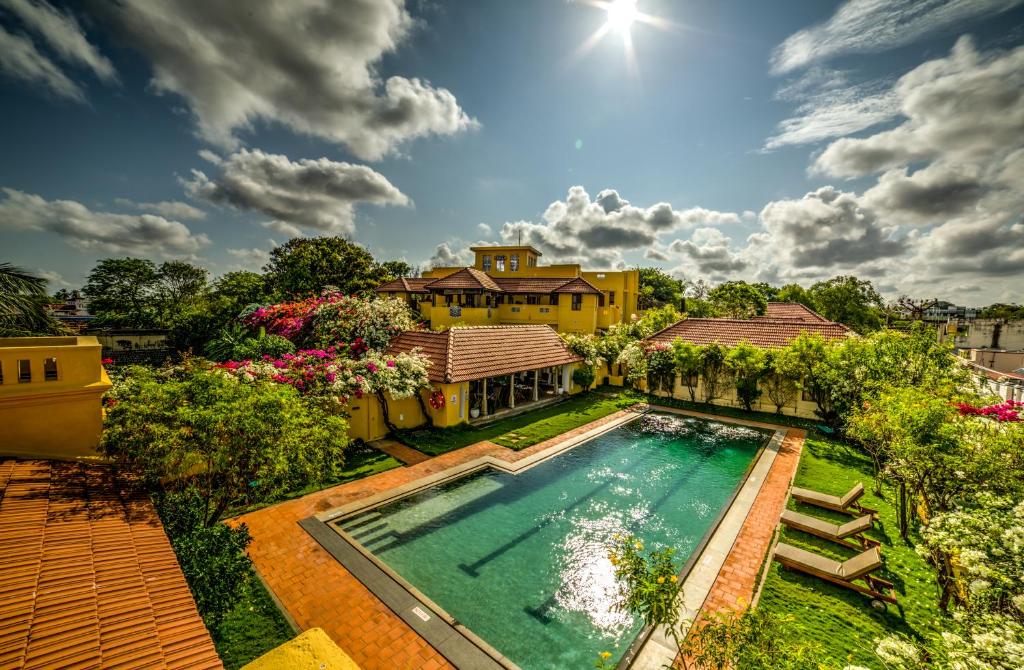 Chettinadu的住宿－Visalam Chettinad Palace - CGH Earth，享有带游泳池的房屋的空中景致