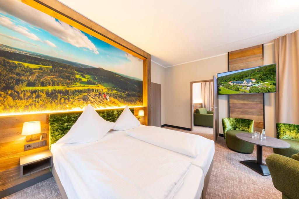 Hotel Waldmühle في تسيلا-ميليس: غرفة في الفندق بها سرير و لوحة كبيرة على الحائط