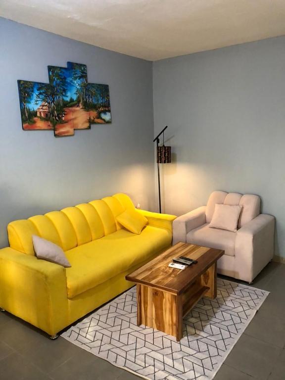 a living room with a yellow couch and a coffee table at Appart F2 plein centre in Klétigan