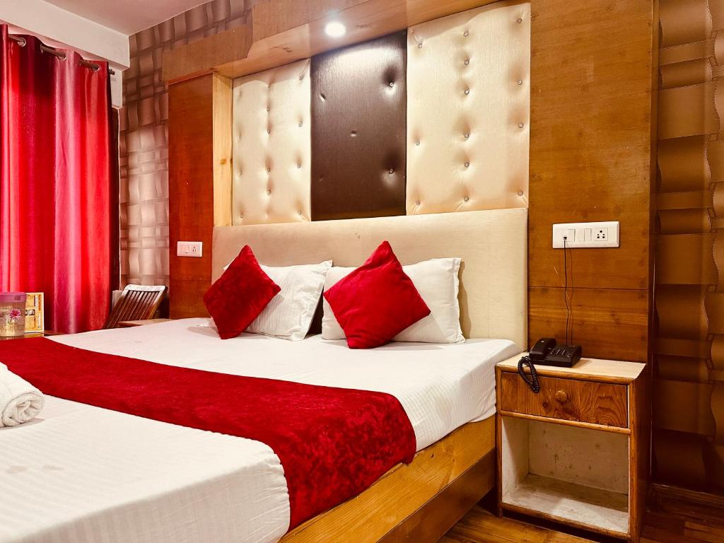 a hotel room with two beds with red pillows at WooibHotels The Solitaire in Manāli