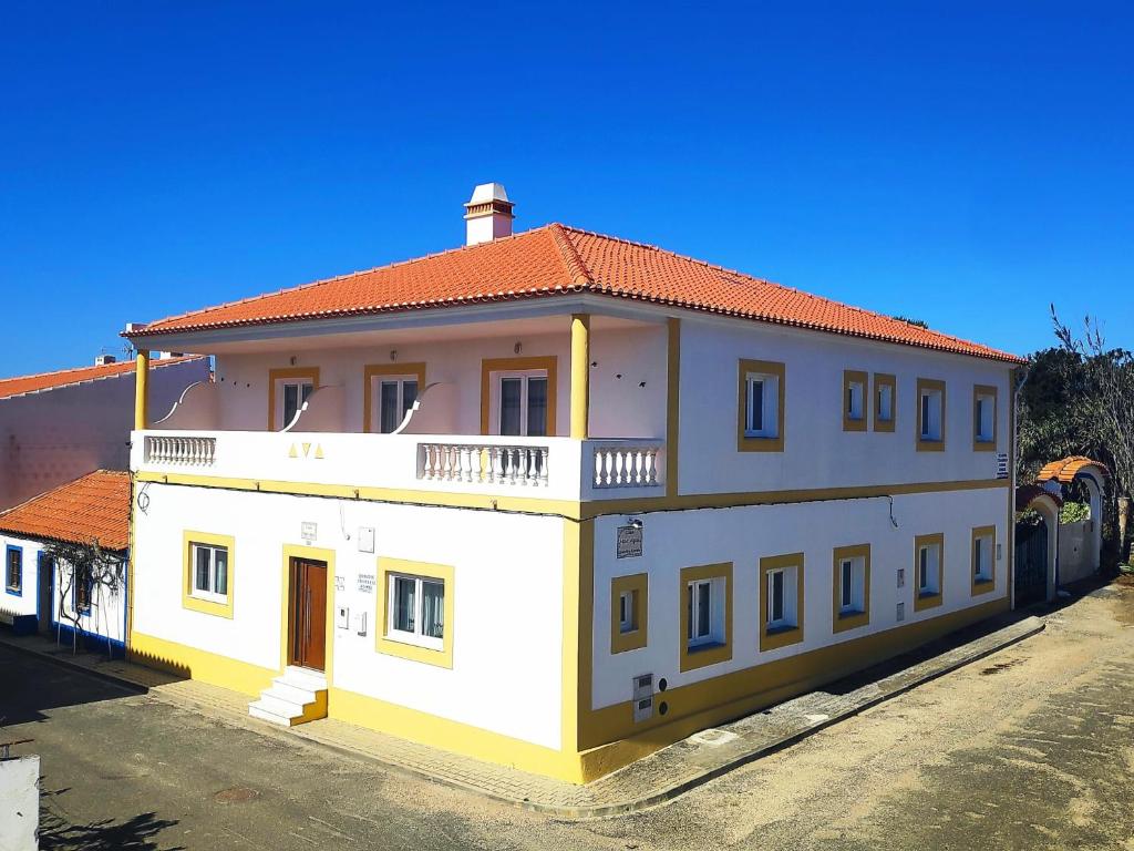a large white building with a red roof at Casa Mar Azul in Vila Nova de Milfontes