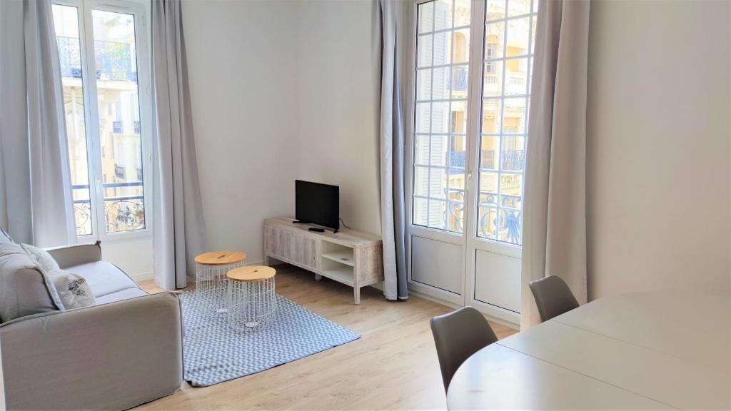 un salon avec un canapé, une télévision et une table dans l'établissement Hypercentre lamartine 308, à Nice
