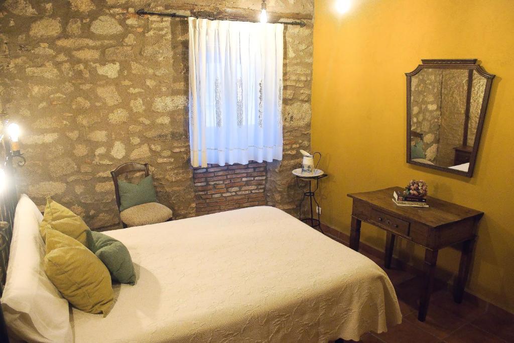 a bedroom with a bed and a mirror and a table at Casa Rural Las Martas in Acebo