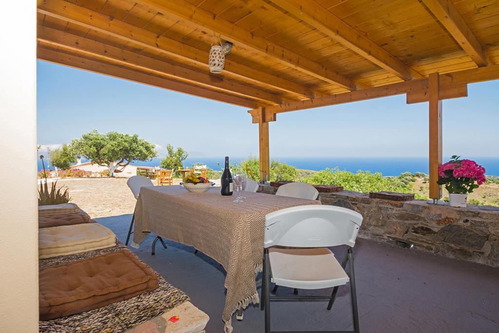 a table and chairs on a patio with the ocean at Two little houses with panorama view in Kýthira