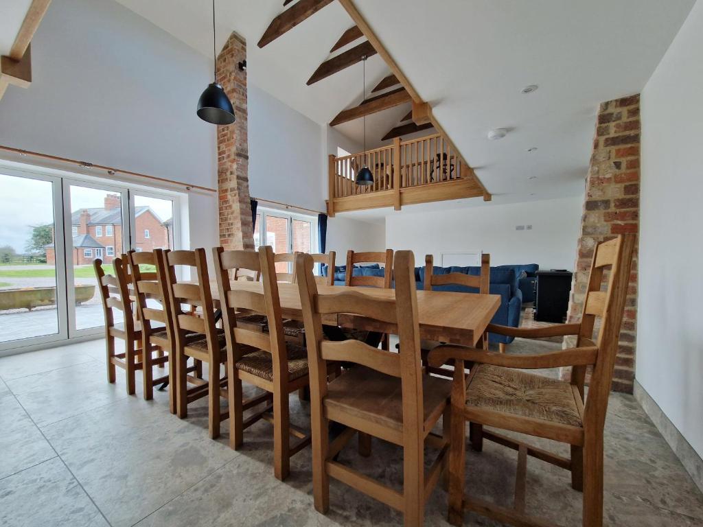 a dining room with a wooden table and chairs at The Hayloft in Lincolnshire