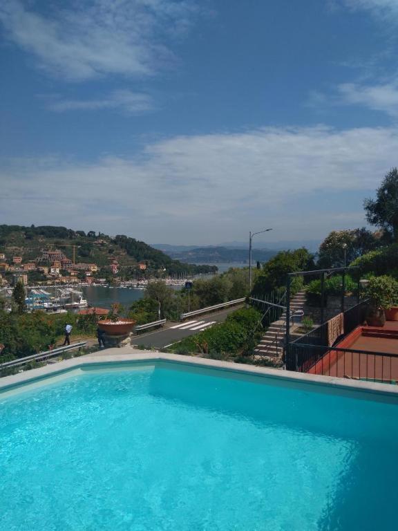a large blue swimming pool with a view of a city at Casa Maggiali in Portovenere