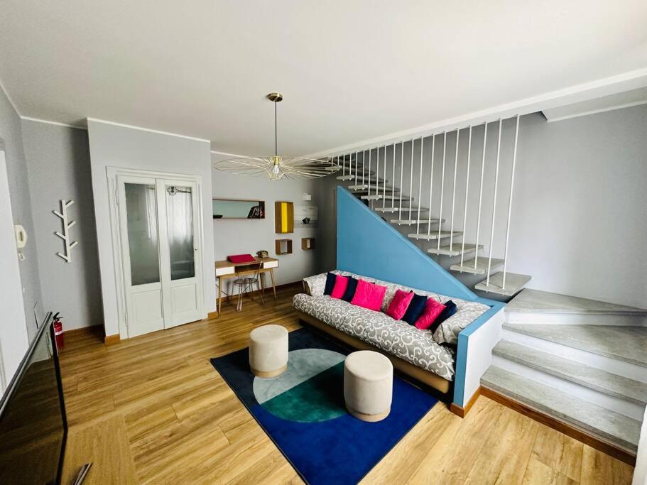 uma sala de estar com um sofá e uma escada em Appartamento Stadio em Cremona