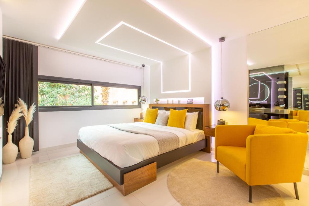 1 dormitorio con 1 cama y 1 silla amarilla en Escale VIP Cœur de l'Hivernage en Face du Sofitel, en Marrakech