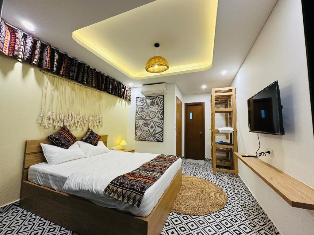 a bedroom with a bed and a flat screen tv at Wins House - khách sạn in Phu Quoc