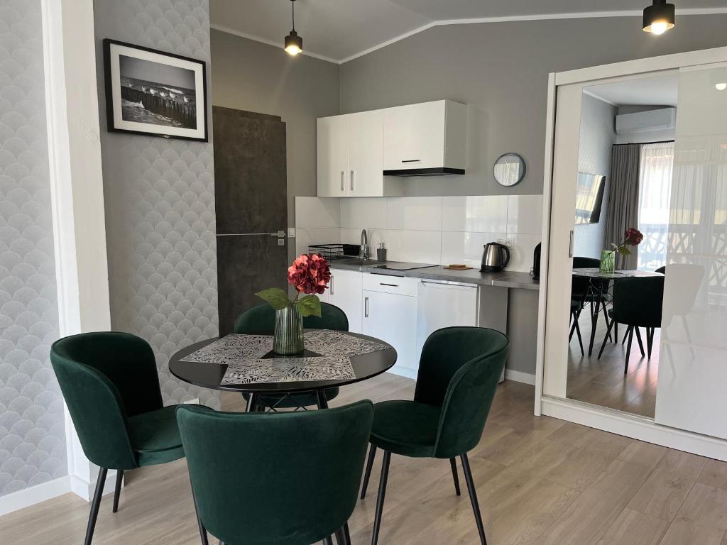 a kitchen and dining room with a table and chairs at Apartamenty BLAST nad morzem Chłopy in Chłopy