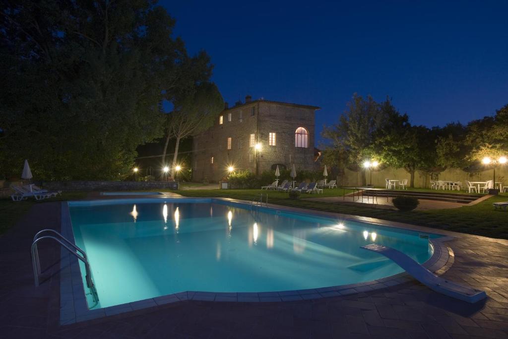 a swimming pool in front of a building at night at Borgo San Lorenzo a Linari in San Rocco a Pilli