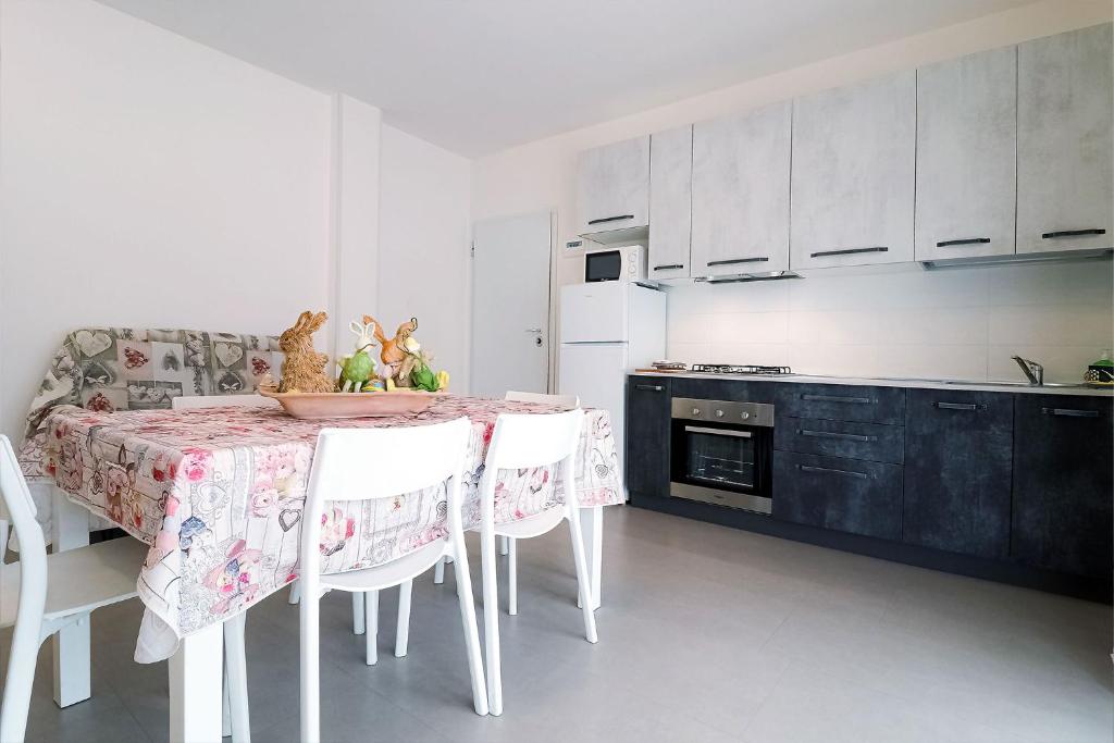 a kitchen with a table and chairs and a kitchen with a stove at Appartamenti Gherbin in Lido di Jesolo