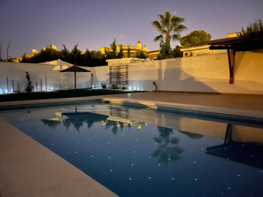una piscina en medio de una casa por la noche en CHALET CON PISCINA PRIVADA, en Torrevieja
