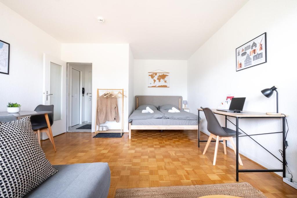 a bedroom with a bed and a desk with a desk at Studioapartment mit Küche und großem Balkon in Flensburg