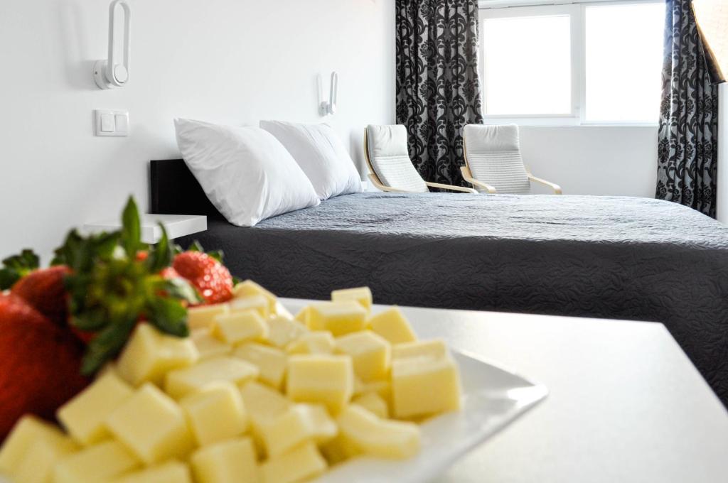 un plato de queso en una mesa junto a una cama en Cozy Seaside Studio Apartment C - Faraway, en Lagoa