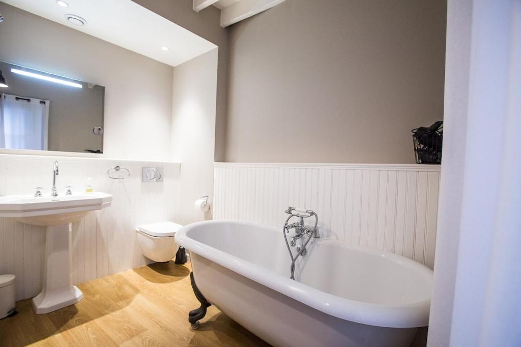 łazienka z wanną, umywalką i toaletą w obiekcie Centrally located, refurbished modern flat with views over the historic port w mieście Honfleur