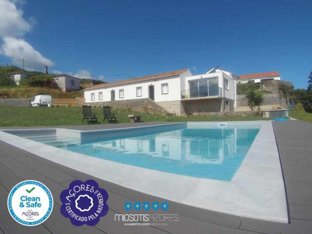 a large swimming pool in front of a house at Casas do Forneiro O Horizonte T2 in Nordeste