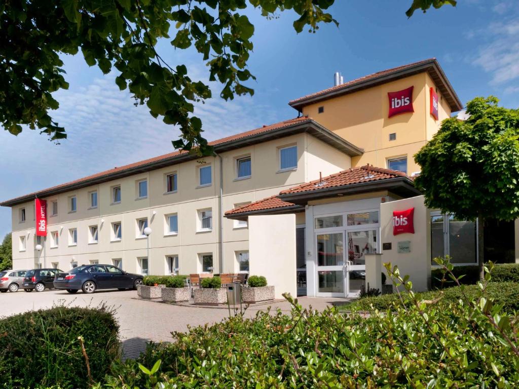 a hotel building with a car parked in a parking lot at ibis Köln Frechen in Cologne