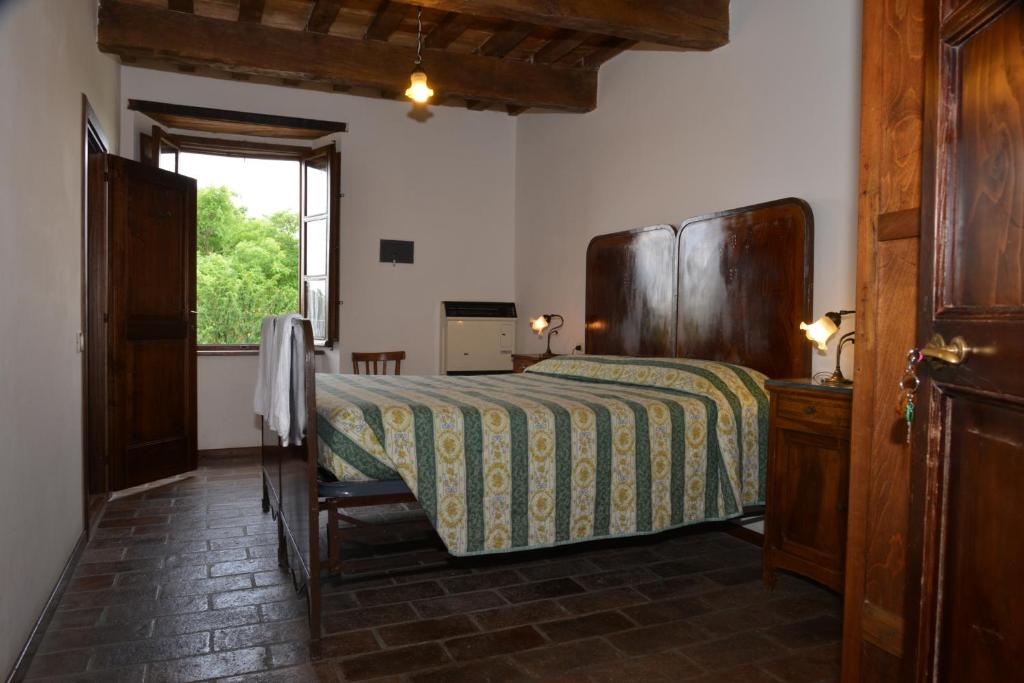 a bedroom with a bed in a room with a window at Villa Pascolo in Costacciaro