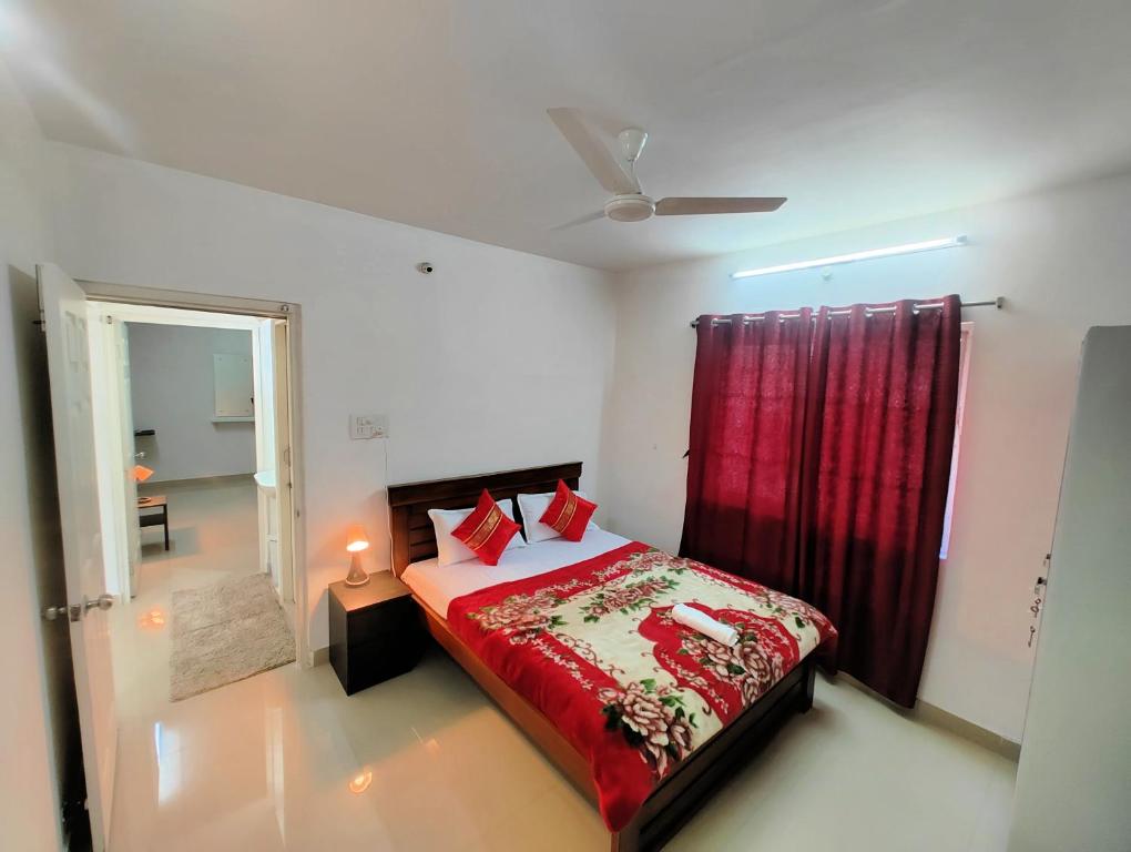 1 dormitorio con cama y cortina roja en NK Homes -Serviced Apartments - 2 BHK Homestay, Fast Wifi, Fully Furnished, en Hyderabad