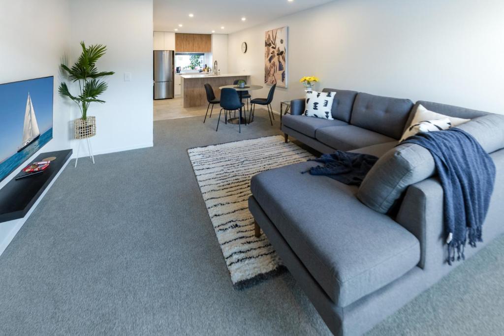 een woonkamer met een bank en een tafel bij City Lights Retreat with Carpark 2 Bed 2 Bath in Christchurch