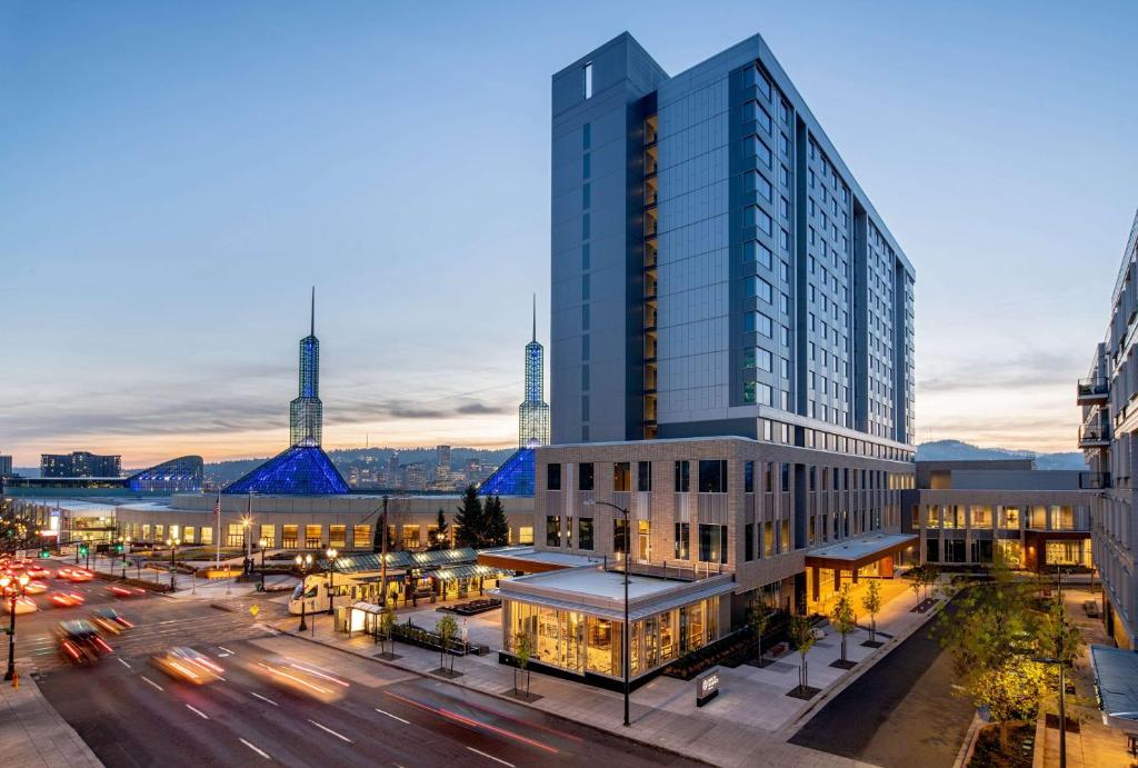 a tall glass building in a city with a street at Hyatt Regency Portland at the Oregon Convention Center in Portland