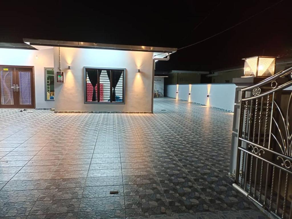 un bâtiment vide avec un portail la nuit dans l'établissement Pantai Dickson Stay 3838 with Private Pool, à Port Dickson