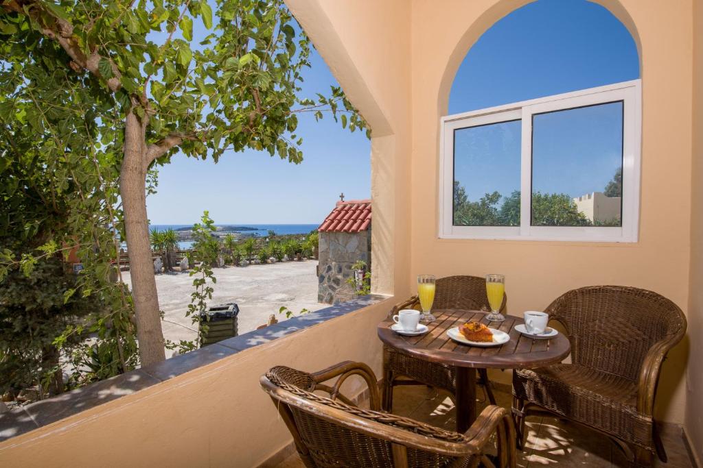 a patio with a table and chairs and a window at Elafonisi Village in Elafonisi