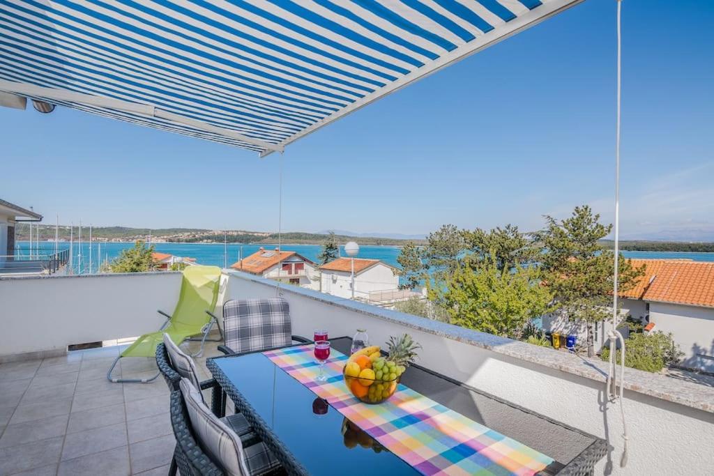 a blue table on a balcony with a view of the ocean at Nice apartment with balcony very close to the sea in Klimno
