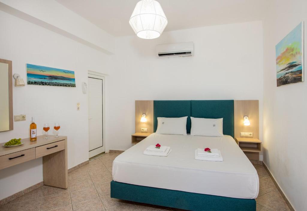 a bedroom with a large white bed and a desk at Elafonisi Village in Elafonisi