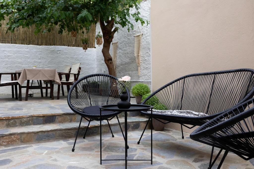 d'une terrasse avec 2 chaises et une table avec un vase. dans l'établissement Irida’s detached house with lovely garden/yard in Athens city center, à Athènes