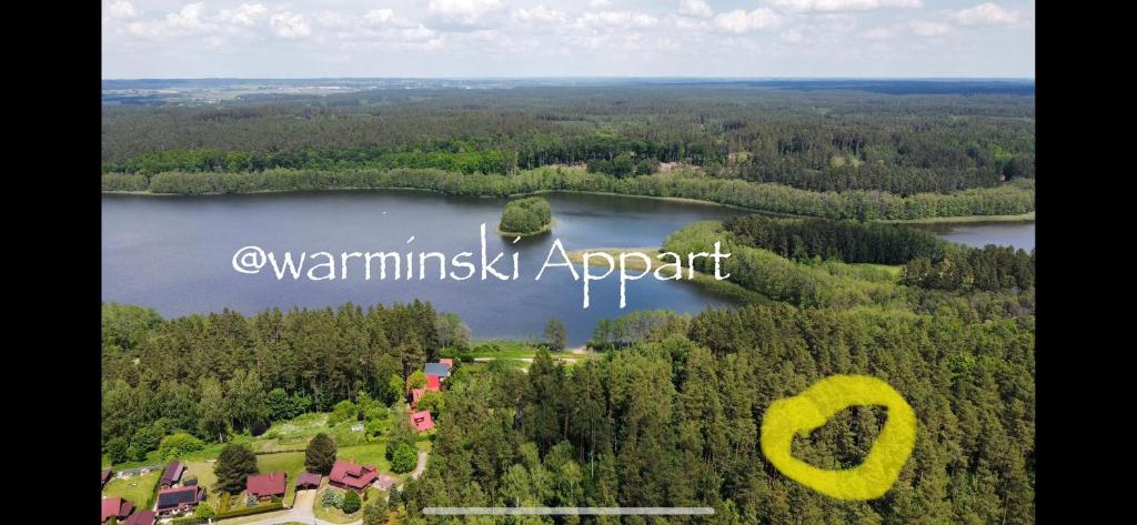 an island in the middle of a lake with trees at I - Apartament na Warmi dla rodzin z dziećmi in Gietrzwałd