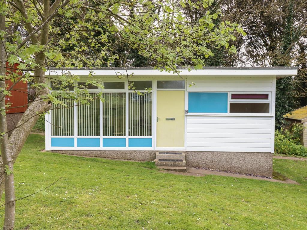 a white and blue garage with a gate at 107 Kings Chalet Park in Cromer