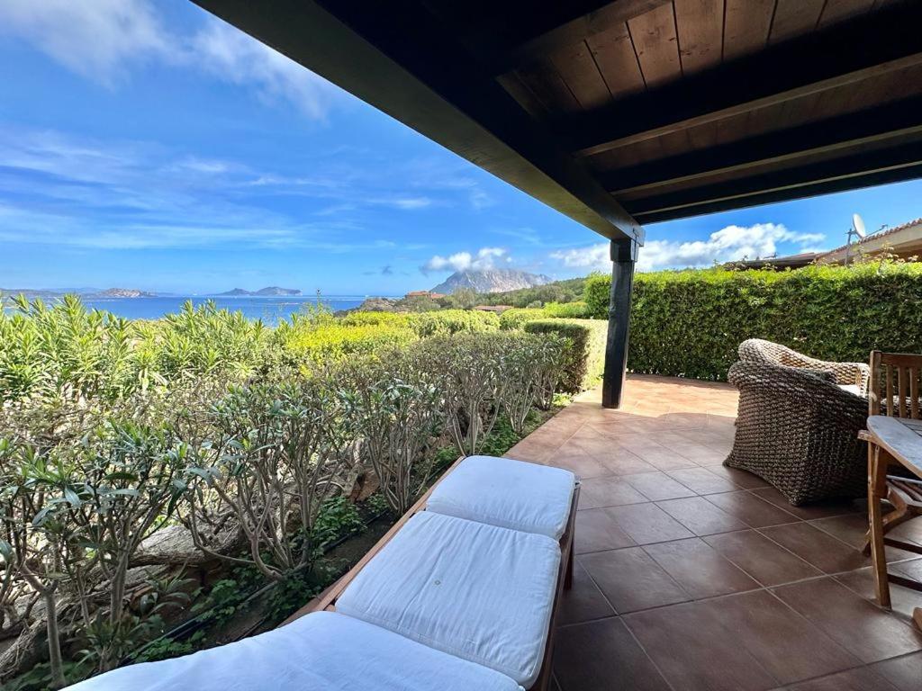 a patio with a bench and a view of the ocean at Residence Domos De Rocca in Monte Petrosu