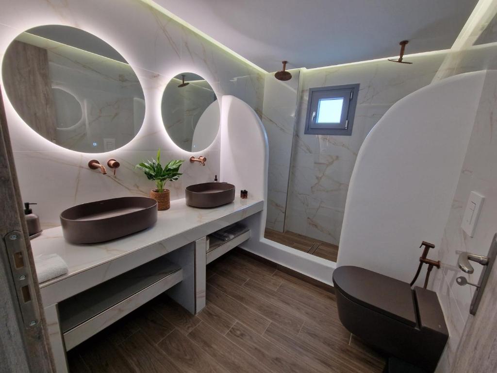 a bathroom with two sinks and two mirrors at Aerial Apartment in Karterados