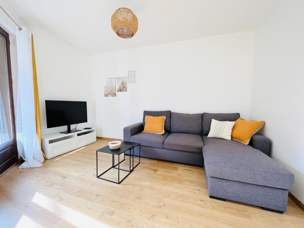 a living room with a couch and a tv at le Clos des Trolles - Hauteurs d'Annecy in Annecy