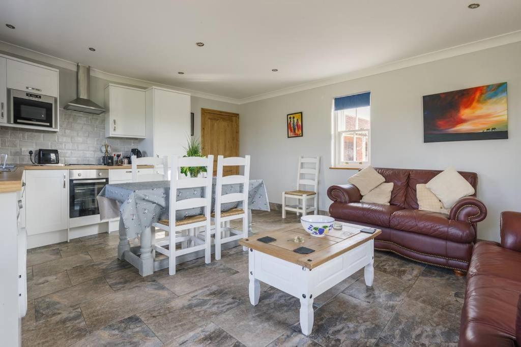 un soggiorno con divano e tavolo di Bainvalley Cottages - The Shamba, sleeps 4 a Lincolnshire