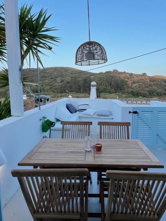a wooden table and chairs on a patio with a view at New! Casa do Mar - Pedralva - Sagres- Surf & Nature in Vila do Bispo