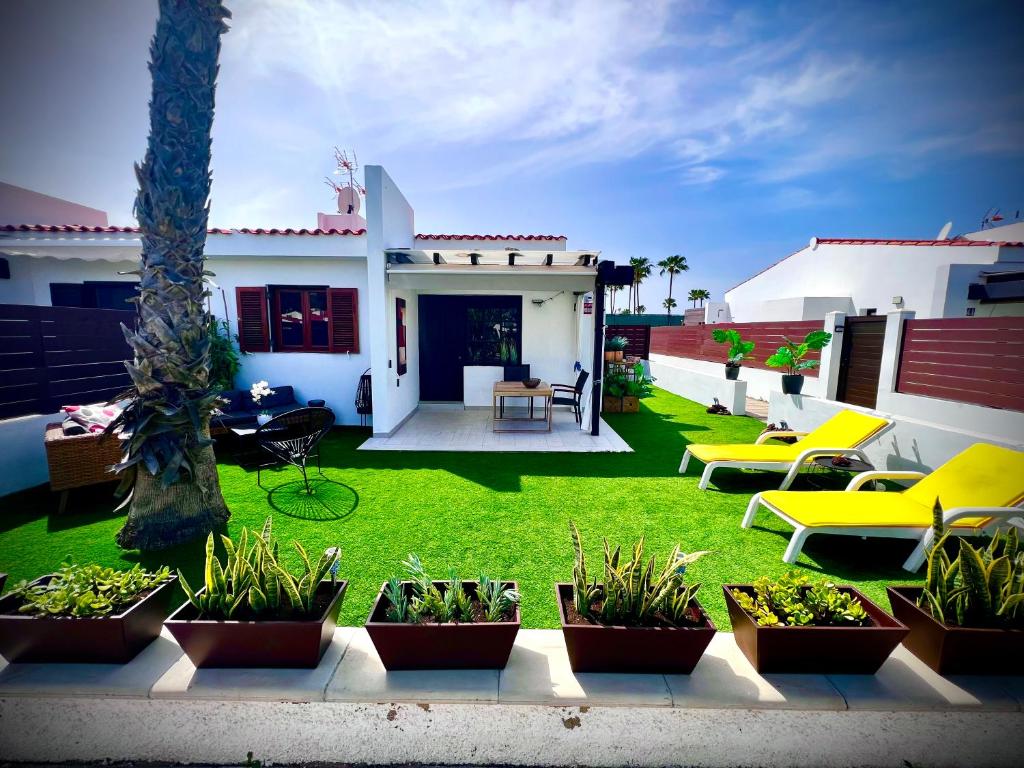 a patio with plants and chairs in a yard at Escarabajo Bungalow il Maggiolino in Maspalomas