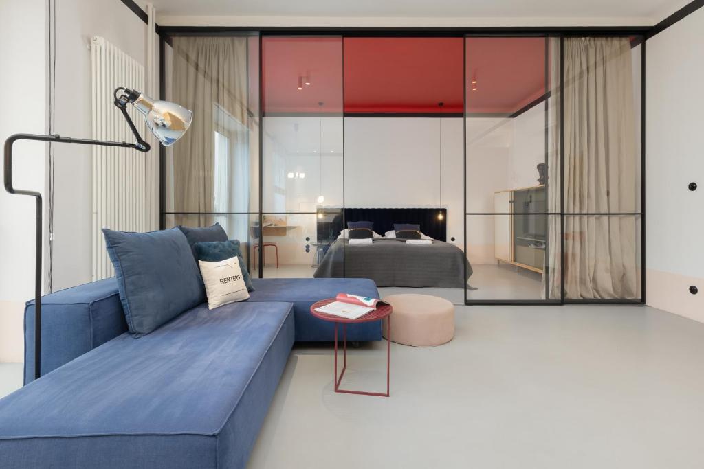 a living room with a blue couch and a bed at Marszałkowska 140 Apartments in the Center of Warsaw by Renters in Warsaw