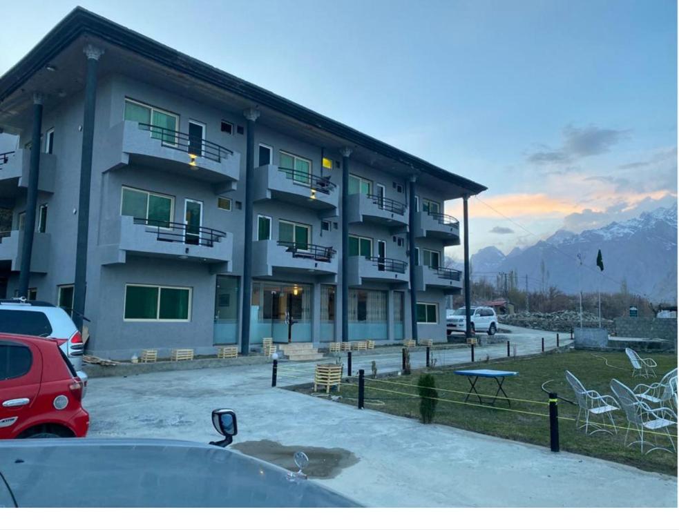 a large building with a parking lot in front of it at Eat and Read Hotel in Skardu