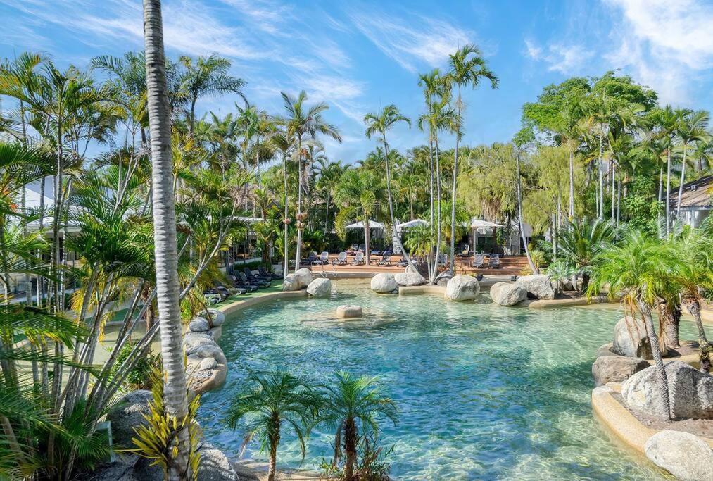 uma piscina num resort com palmeiras em Reef Resort, Lagoon Pool Scooters, Bar 1R em Port Douglas