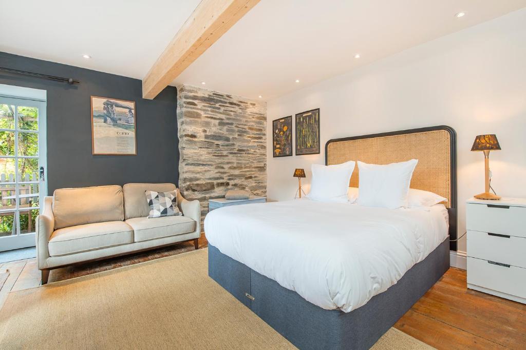 a bedroom with a large bed and a couch at The Garden Room Apartment in Cardigan