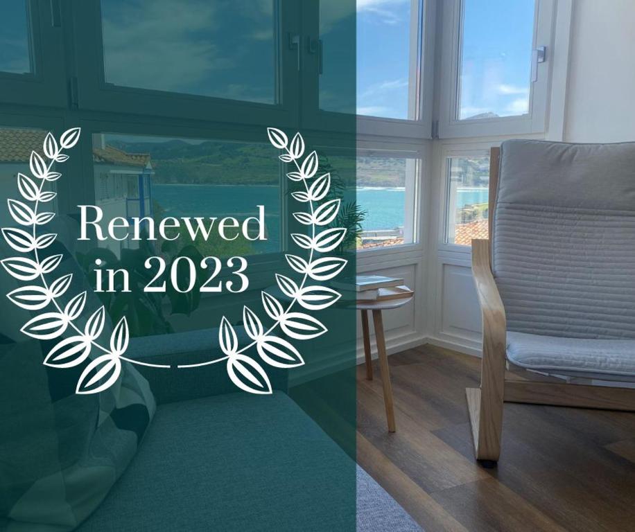 a room with a chair and a sign that reads reviewed in at APARTAMENTOS ARATUSTE - News a estrenar in Mundaka
