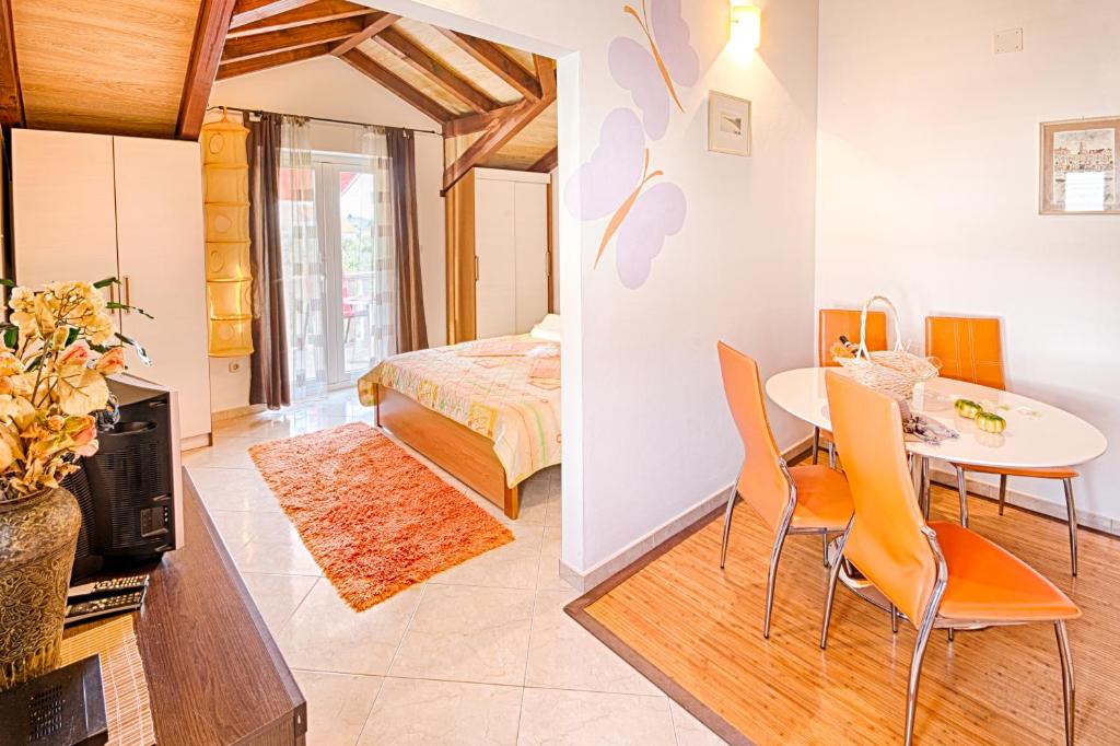 una camera da letto e un soggiorno con tavolo e sedie di Apartmani Rita a Milna