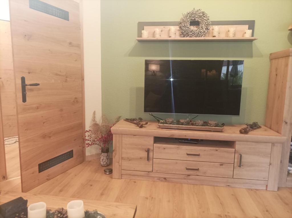 uma sala de estar com televisão numa cómoda de madeira em KuschelBude em Braunlage